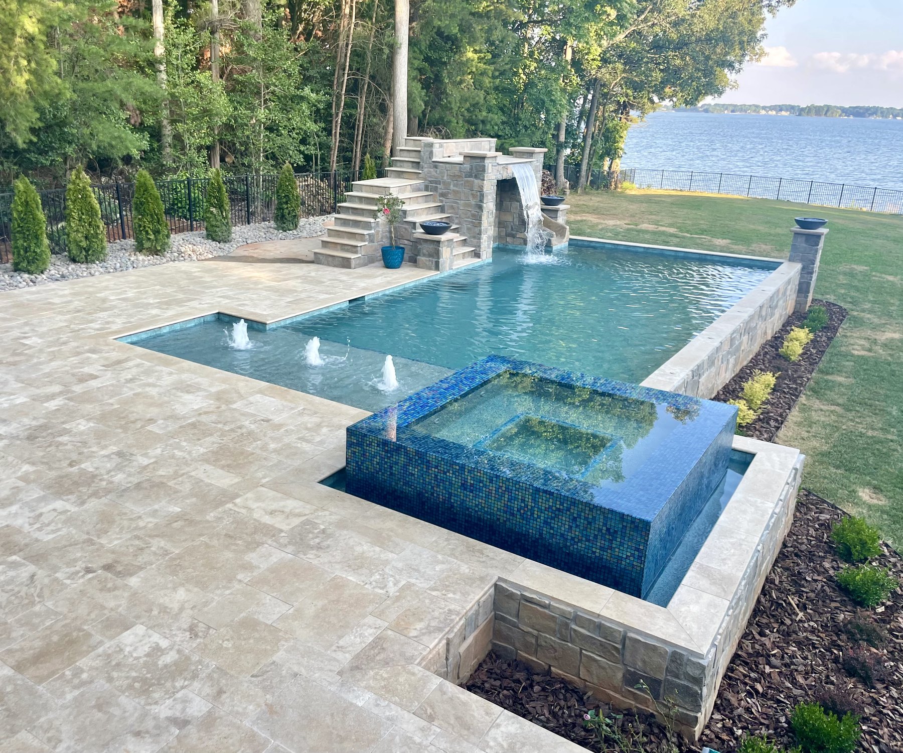 Completed luxury pool with waterfall, spa and Lake Norman backdrop